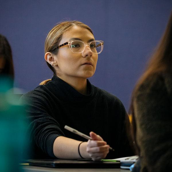 An Agnes Scott public health major student takes notes during a lecture.